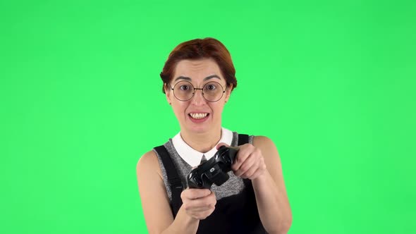 Portrait of Funny Girl in Glasses Is Playing Video Game Using Wireless Controller and Rejoicing