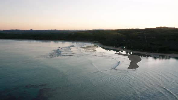 Bright sky during sunrise in tropical bay in Fiji with calm seawater, aerial