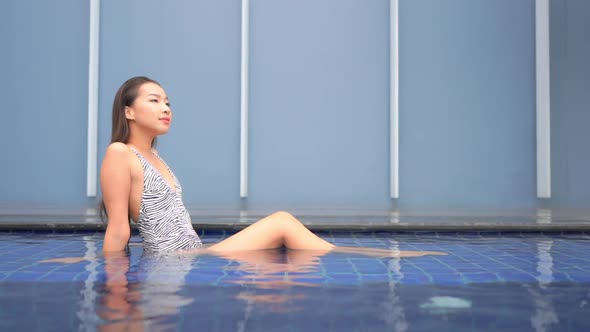 Young asian woman enjoy around outdoor swimming pool for leisure