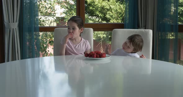 Cute Children Eating Fresh Ripe Strawberries at Home