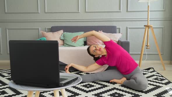 Woman Exercising While Watching Online Training