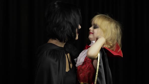 Woman and Child Dracula. Halloween Vampire Make-up. Kid with Blood on Her Face