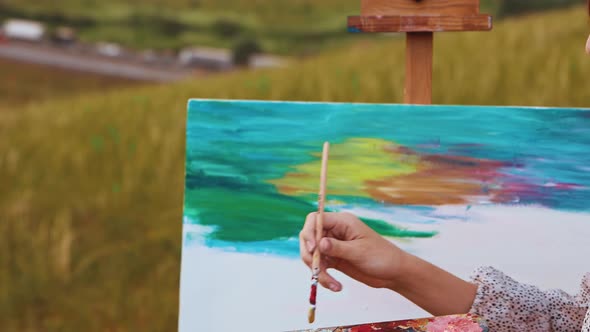 Young Woman Drawing a Painting Inspired By the Sunset and Landscape