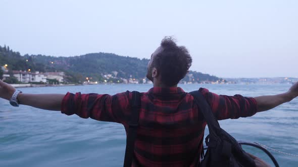 Man opening his hands with happiness on the ferry.