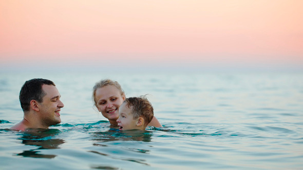 Young Parents With Son Bathing In Sea