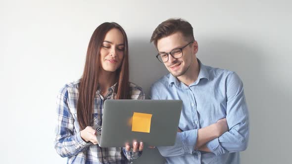 Two Young Architects Discussing Project of New Contemporary Skyscraper Using Laptop