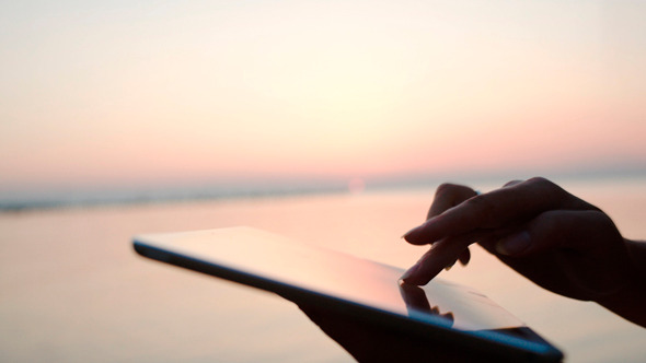Female Hands Typing On Tablet Pc By Sea At Sunset