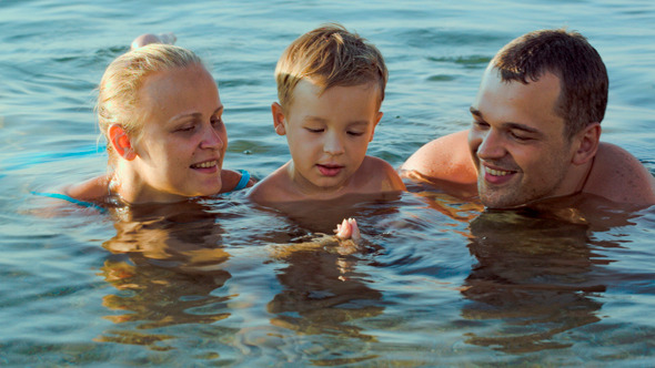Parents And Son In Sea During Summer Vacation