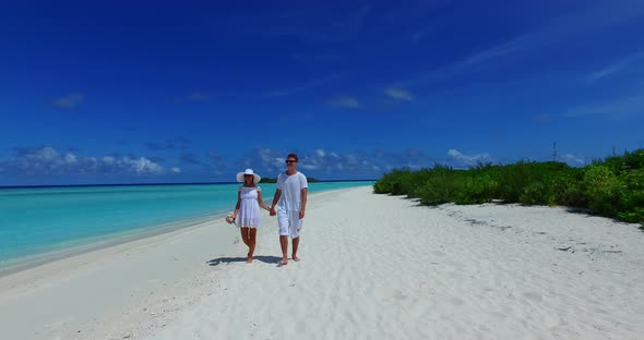 Young boy and girl in love dating on vacation have fun on beach on white sand 4K background