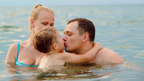 Lovely Family With Child Bathing In Sea