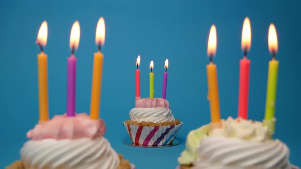 Birthday Cupcake with Lit Candle on Blue Background