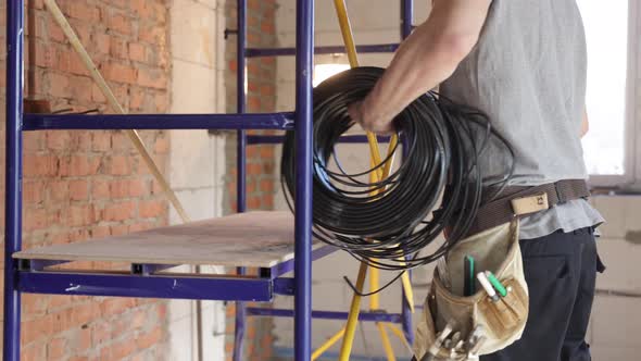 Electrician contractor with electric cable at a construction site.