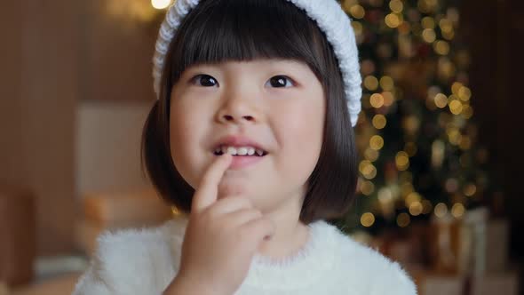 Korean Girl Child in a White Knitted Sweater and Hat Stands