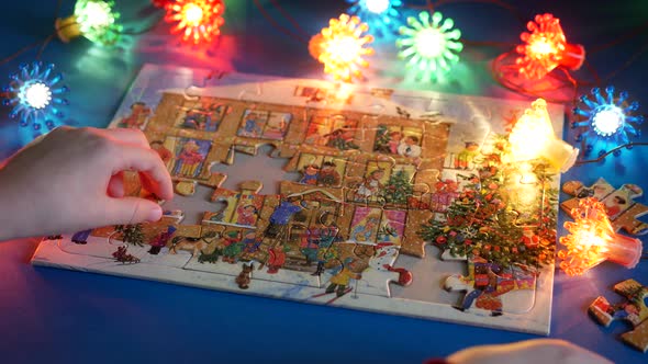 Child putting the pieces of the beautiful Christmas jigsaw puzzle