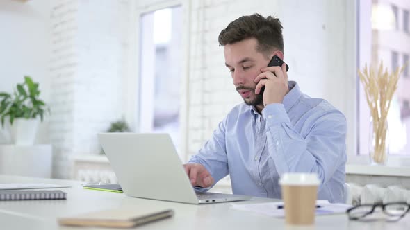 Creative Man Talking on Smartphone at Work