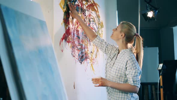 Joyful Woman is Painting with Her Hands in the Art Studio