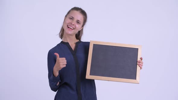 Happy Young Beautiful Businesswoman Holding Blackboard and Giving Thumbs Up