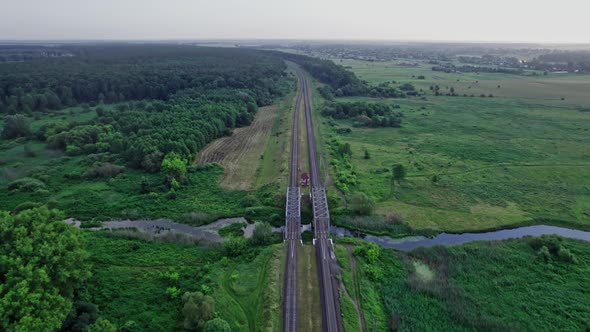 Railway Bridge Among Green Meadows Over a Small River in the Countryside