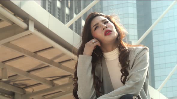 Lay off concept. Fired business woman sitting on stairs of office building outside. Depressed