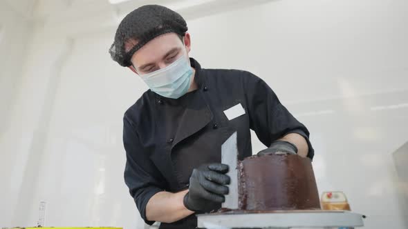 Front View of Concentrated Young Handsome Man in Covid Face Mask Spinning Rotating Table Decorating