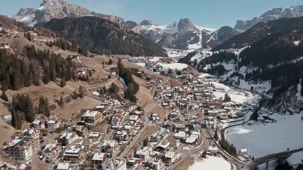 Descending drone shot over beautiful snowy mountain village in the dolomites