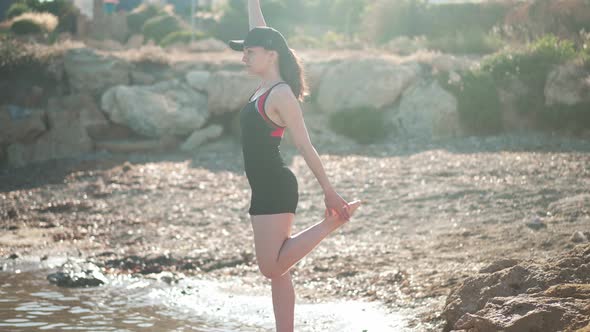 Confident Beautiful Woman Raising Leg and Hand in Slow Motion Looking Away Standing in Sunrays