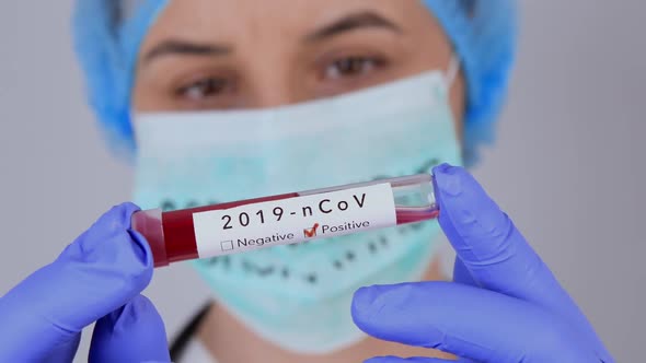 Nurse Holding Test Tube with Positive Coronavirus 