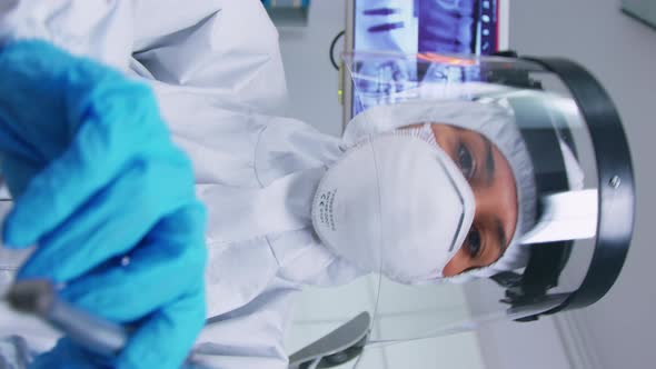 Vertical Video Patient Pov of Dentist Holding Dental Tools Wearing Covid Protection Suit