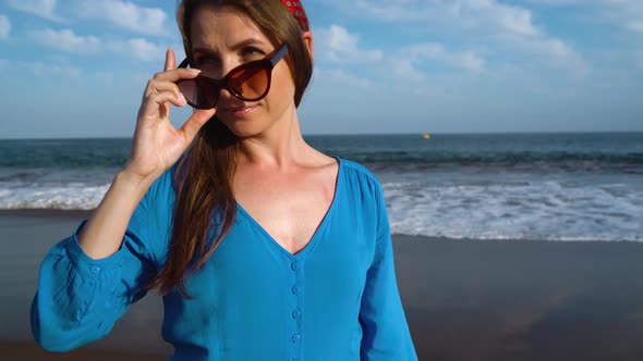 Portrait of a Woman in a Beautiful Blue Dress on a Black Volcanic Beach