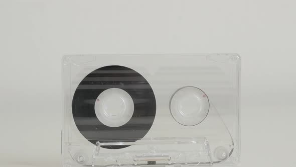 Tilting on vintage transparent  compact  audio cassette on white background 4K 2160p 30fps UltraHD f