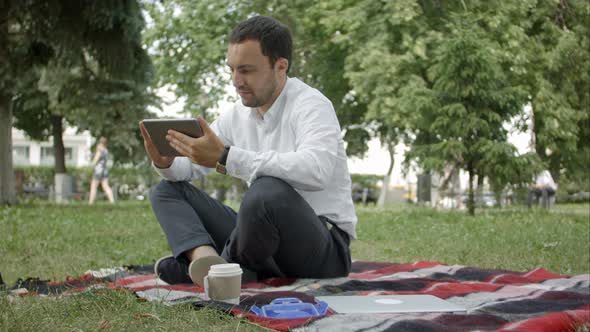 Businessman at the Park with Tablet