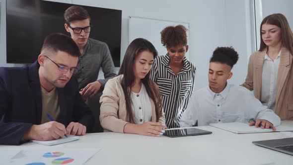 Asian Businesswoman Presenting Project to Team at Meeting