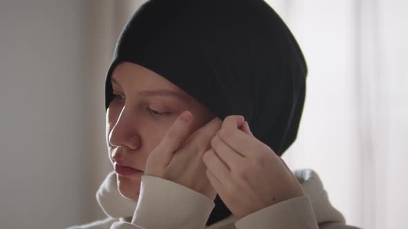 Young Woman Fixes Her Hijab Then Looks in the Camera