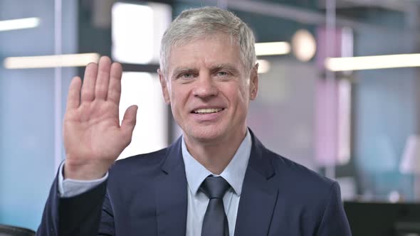 Portrait of Middle Aged Businessman Waving and Smiling