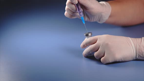 Mixing of Medicine. Doctor Piercing the Lid of the Ampoule with Syringe