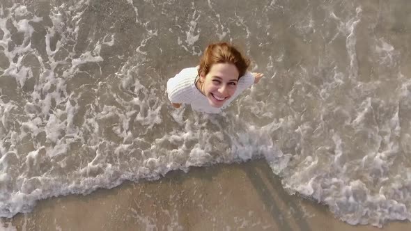 Smiling Pretty Girl Enjoying Amazing Morning Spinning with Stretched Out Arms Looking Up at Camera