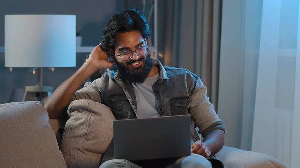 Arabic Indian Bearded Man Millennial Guy Businessman Freelancer Sitting at Home Sofa in Evening