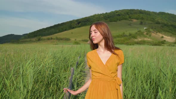 Young woman walking in a reed field