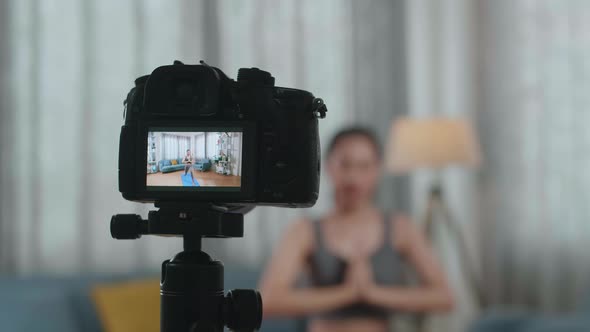 Camera Monitor Recording Asian Trainer Female In Sports Clothes Doing Yoga In High Lunge Pose