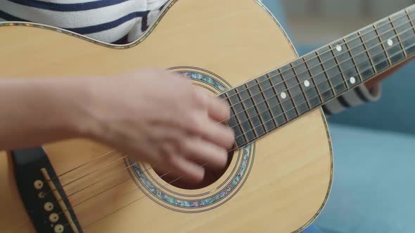 Close Up Of Woman's Hands Playing A Guitar At Home