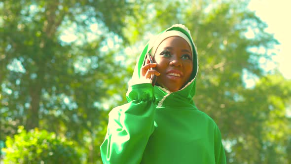 Latin Hispanic Arab Woman in Green Muslim Dress with Modern Bright Make Up and Nose Piercing Talking