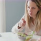 Woman eating salad and looking at laptop in kitchen, Milan, Italy - VideoHive Item for Sale