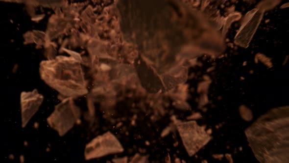 Super Slow Motion Detail Shot of Falling Raw Chocolate Chunks on Black Background at 1000Fps