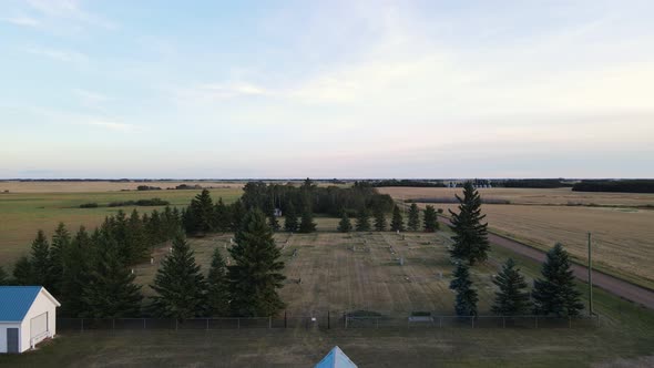 Pristine white and blue country church next to a small cemetery at sunset in Alberta, Canada. Wide a