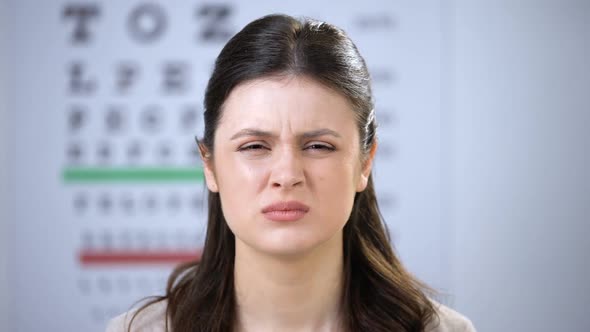 Female Squeezing Eyes, Oculist Putting Refractor on Smiling Lady Patient, Lenses