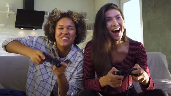 Two Girlfriends Play with Joysticks