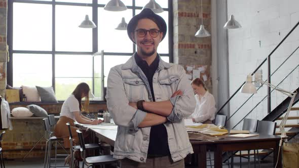 Male Fashion Designer Smiling and Posing for Camera in Sewing Workshop