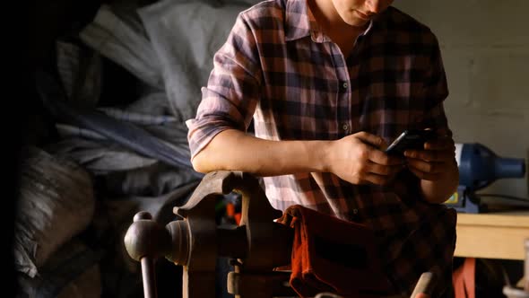 Female metalsmith using mobile phone 4k