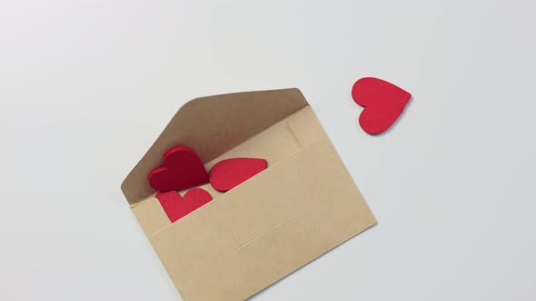 Falling Down Craft Paper Envelope and Many Red Wooden Hearts Inside Getting Out