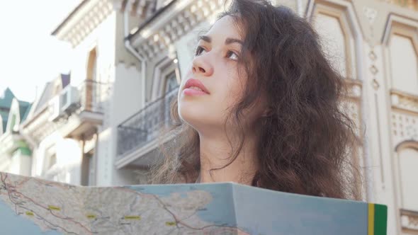 Happy Young Woman Smiling To the Camera Holding a Map